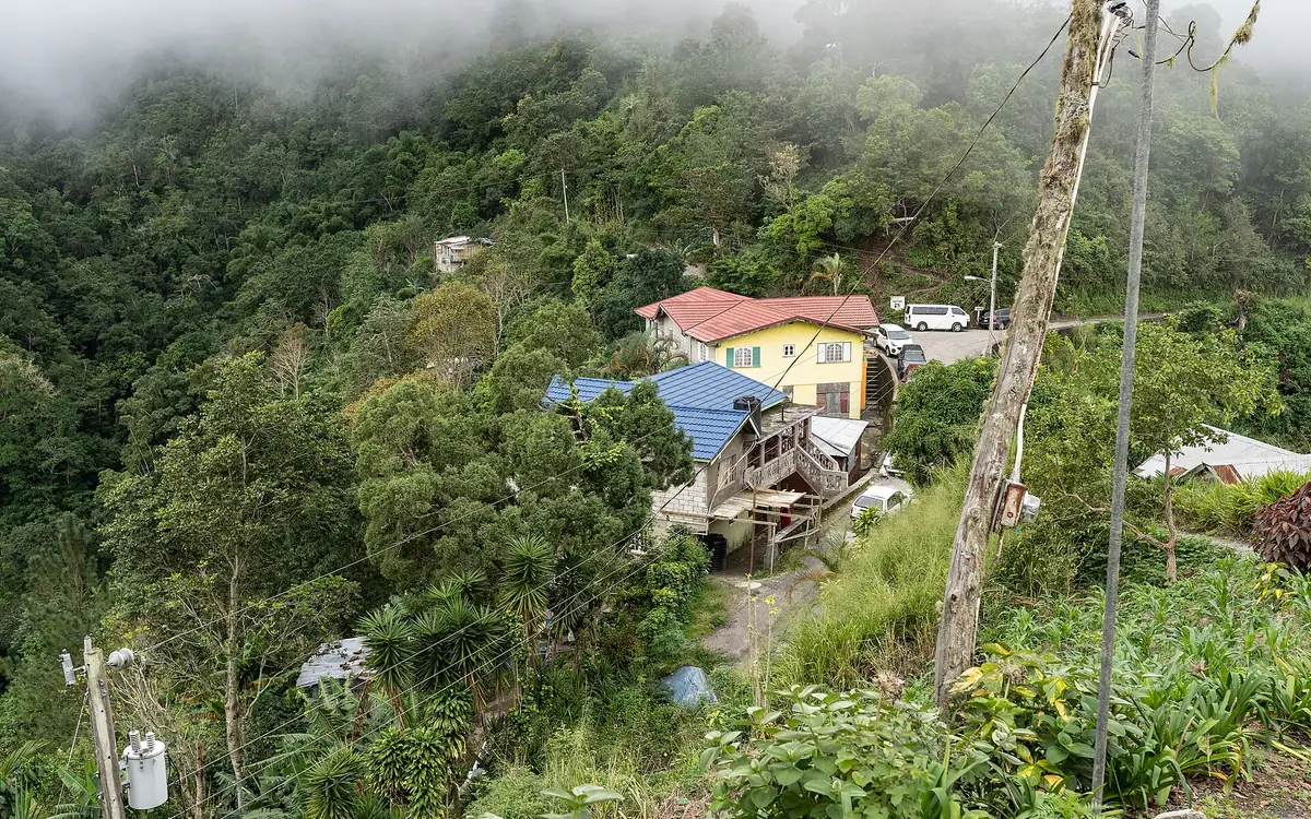 Fog hangs over the village of Section in the Blue Mountains of Portland Parish, Jamaica. The yellow building with the red roof is home to James Dennis' Coffee.